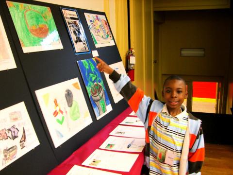 Malyk Reese, 8, points to his drawing titled “Happy Easter!” at the Youth Workers' Alliance Auction